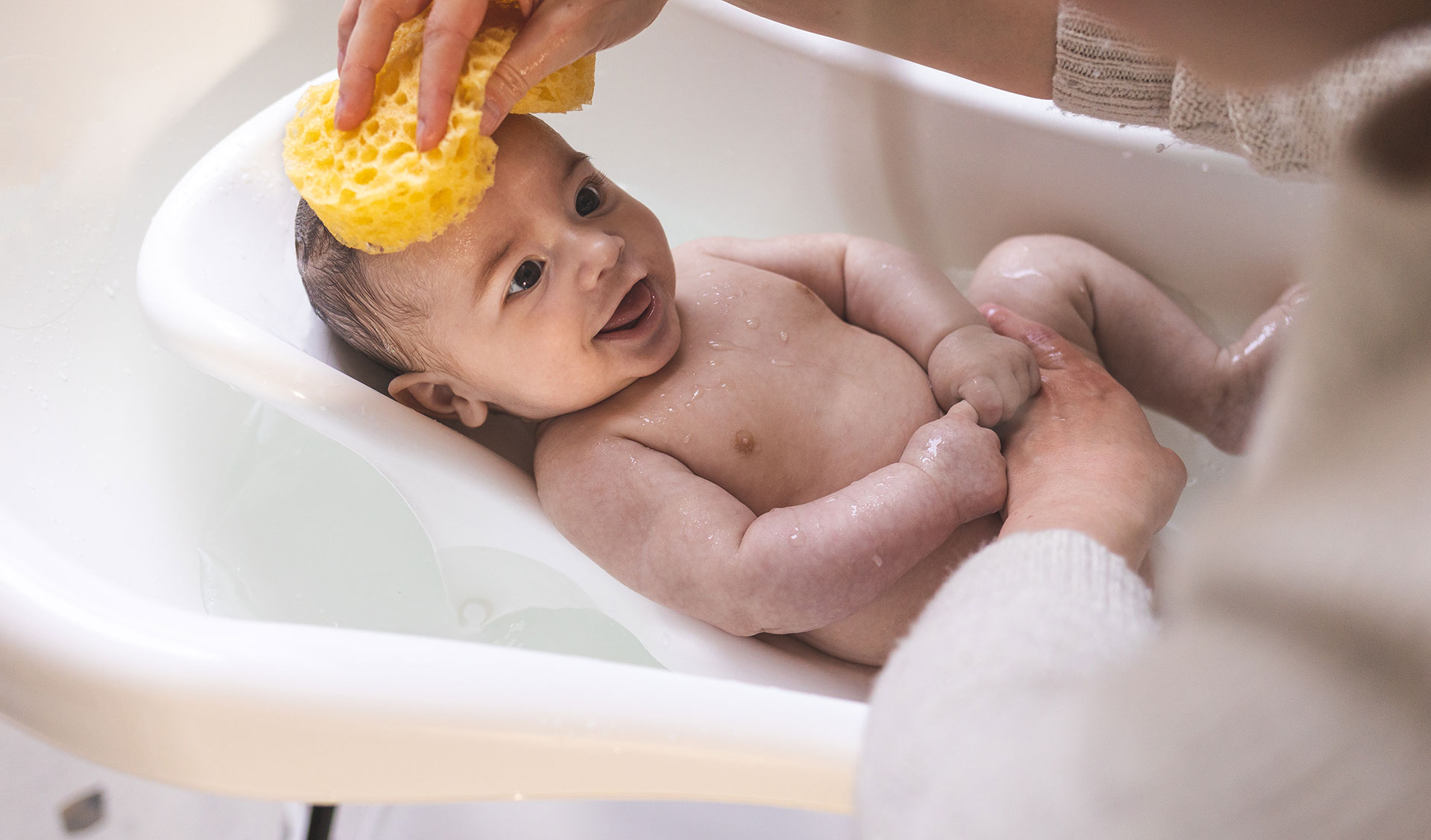 bambino nella vasca mentre gli lavano la testa e massaggiano la crosta lattea.