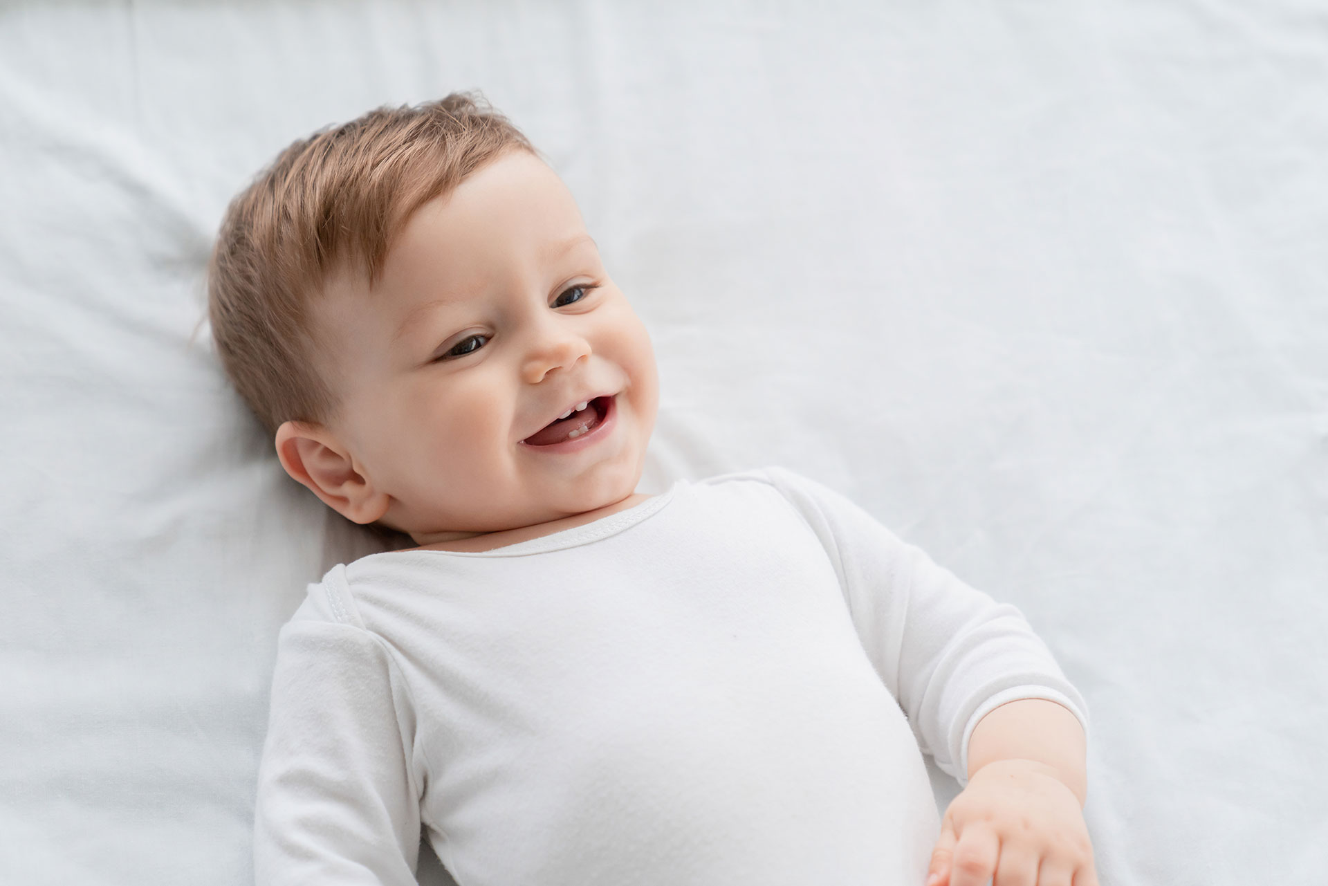 bambino che sorride con i suoi primi denti